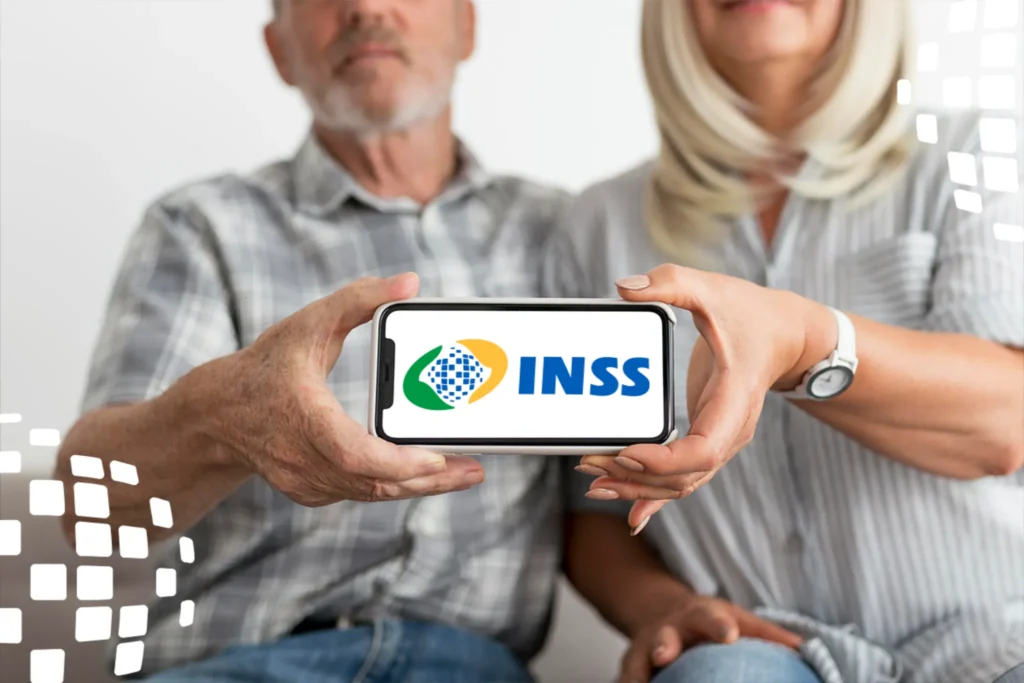 13º salário do INSS: primeira parcela pode ser depositada a partir de abril 2 Casal de aposentados segurando um celular com o logo do INSS, simbolizando o pagamento do 13º salário.