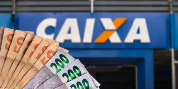 Diversas cédulas de reais exibidas em leque em frente à fachada da CAIXA Econômica Federal