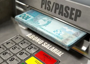 Nota de R$ 100 visível em caixa eletrônico com a etiqueta de saque PIS/Pasep, relacionados ao pagamento de R$ 1.621 para nascidos em fevereiro.