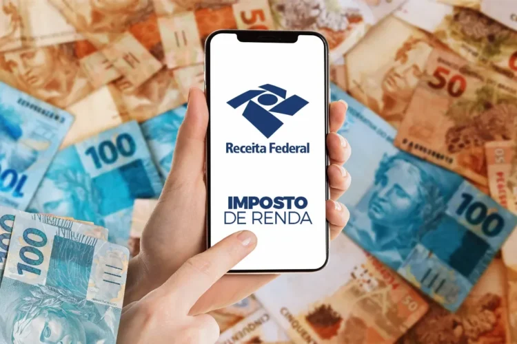 Consulta ao lote residual do Imposto de Renda 2026 é liberada nesta terça-feira (24) 1 Celular mostrando aplicativo da Receita Federal para consulta do lote residual do Imposto de Renda 2026 com notas de real ao fundo