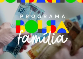 Pessoa segurando notas de R$ 100,00, ilustrando o pagamento do Bolsa Família para beneficiários com NIS final 2, liberado em março de 2026.