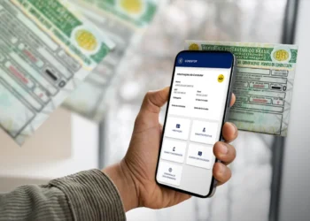 Pessoa segura celular exibindo tela de CNH digital ao lado de carteira física de motorista
