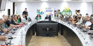 Autoridades e técnicos reunidos em mesa oval discutindo políticas sociais na Sede do Governo Federal