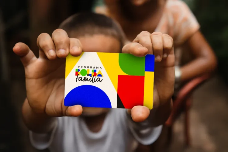 Bolsa Família: Beneficiários com NIS final 8 são contemplados com pagamento nesta sexta (27) 1 Criança segurando cartão colorido do Programa Bolsa Família com fundo desfocado