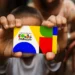 Criança segurando cartão colorido do Programa Bolsa Família com fundo desfocado