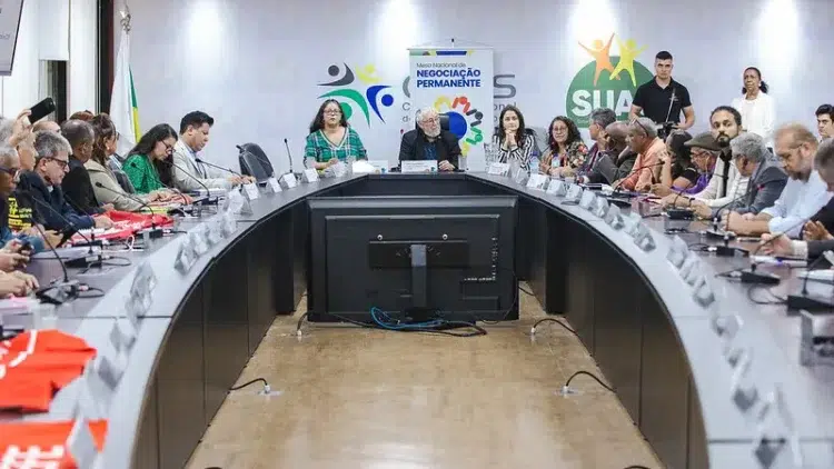 Governo Federal reajusta benefícios em 2026: auxílio-alimentação atinge R$ 1.192 2 Grupo de servidores e autoridades reunidos em mesa oval debatem reajuste de benefícios