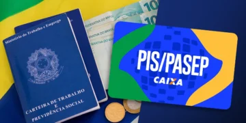 Carteira de trabalho, cartão PIS/Pasep, cédulas e moedas sobre bandeira do Brasil