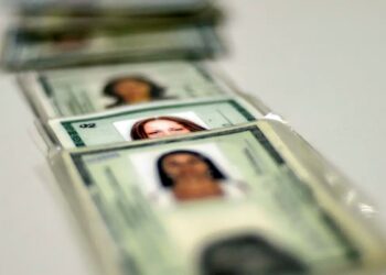 Antigos RGs empilhados, destacando a importância de atualizar para a nova identidade brasileira.