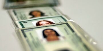 Antigos RGs empilhados, destacando a importância de atualizar para a nova identidade brasileira.