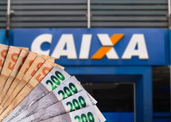 Notas de real brasileiro em frente a uma agência da Caixa Econômica Federal relacionadas ao saque de R$ 6.220 disponível