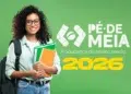 Jovem segurando cadernos coloridos diante de fundo verde ao lado do logo Pé-de-Meia 2026