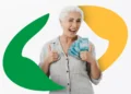 Mulher idosa de cabelos brancos segura notas de R$ 100, fazendo sinal de positivo com logo do INSS ao fundo.