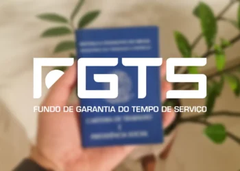Carteira de Trabalho azul sendo segurada por uma mão, logo do FGTS em destaque, planta ao fundo