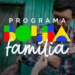 Pai segura criança no colo com logotipo colorido do Programa Bolsa Família sobreposto à imagem.