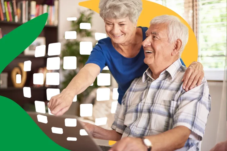 Aposentados e pensionistas recebem 1ª parcela do 13º salário do INSS em breve: confira como consultar 2 Casal de idosos sorridentes olhando para tela de notebook em ambiente residencial aconchegante com estante de livros ao fundo.