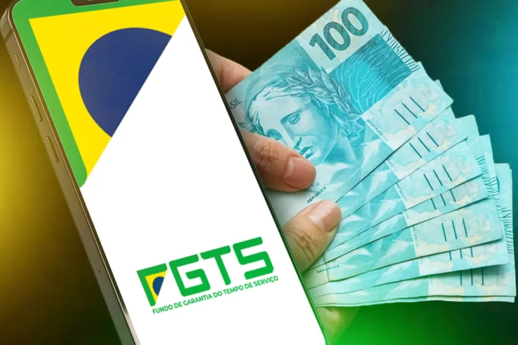 Mão segurando celular com aplicativo FGTS e bandeira do Brasil ao lado de cédulas de R$ 100.