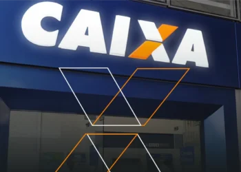 Letreiro Caixa em destaque acima da entrada de agência bancária azul